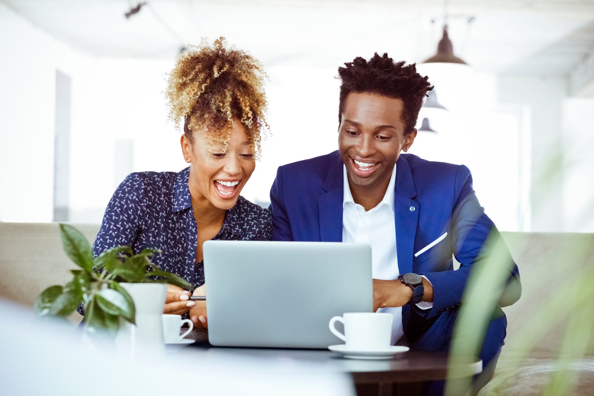 Happy professionals looking at laptop in office